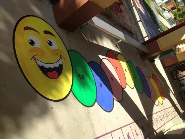 A smiley face is painted on the side of a building — Concrete Colour Solutions in Morisset, NSW