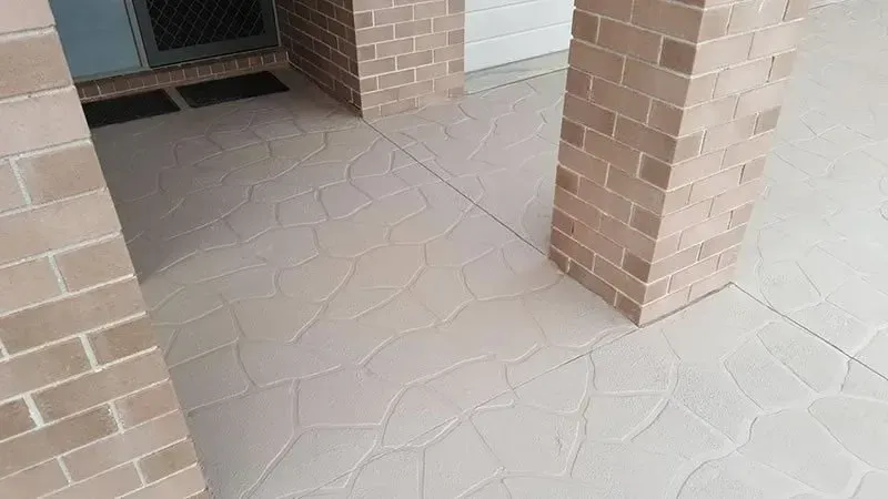 A patio with brick pillars and a concrete floor. — Concrete Colour Solutions in Morisset, NSW