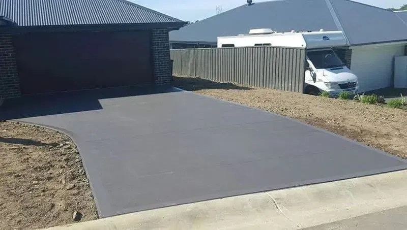 A white van is parked in a driveway in front of a house. — Concrete Colour Solutions in Morisset, NSW
