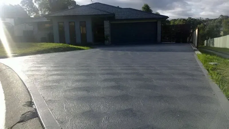A Driveway Leading to A House with A Garage — Concrete Colour Solutions in Morisset, NSW