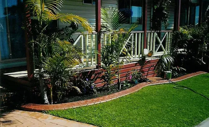 A house with a porch and a lush green lawn — Concrete Colour Solutions in Morisset, NSW