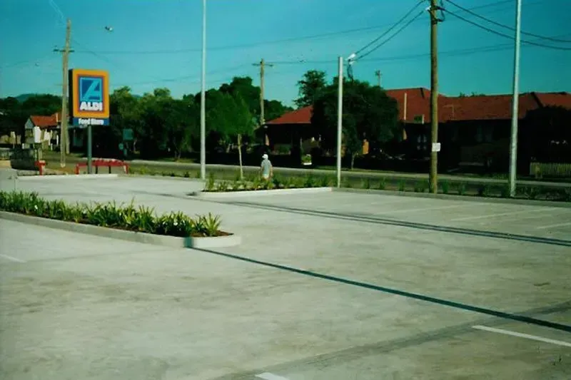 A parking lot with garden dividers — Concrete Colour Solutions in Morisset, NSW