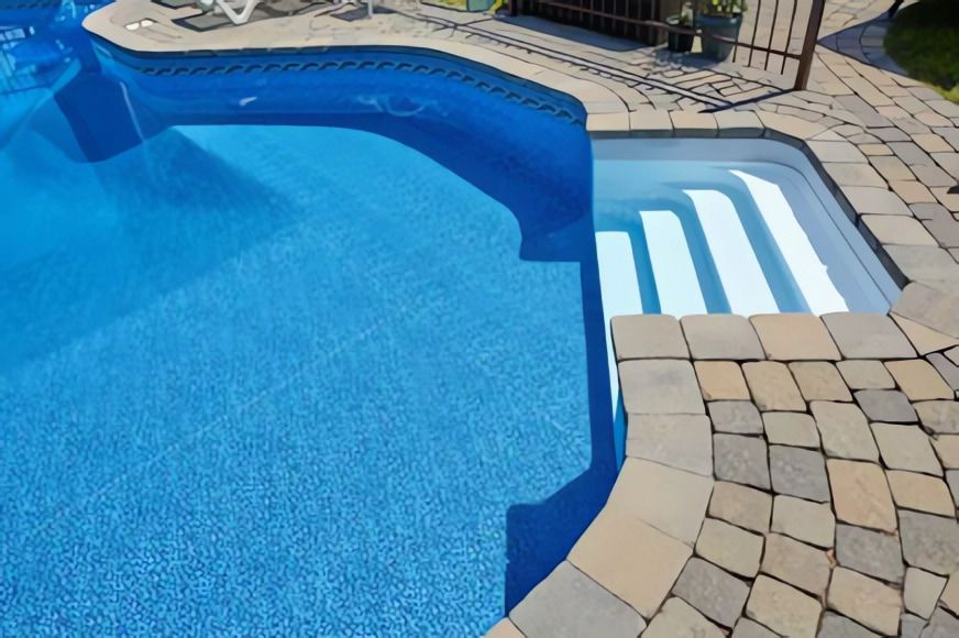 A Blue Swimming Pool with Stairs Leading to It — Concrete Colour Solutions in Morisset, NSW