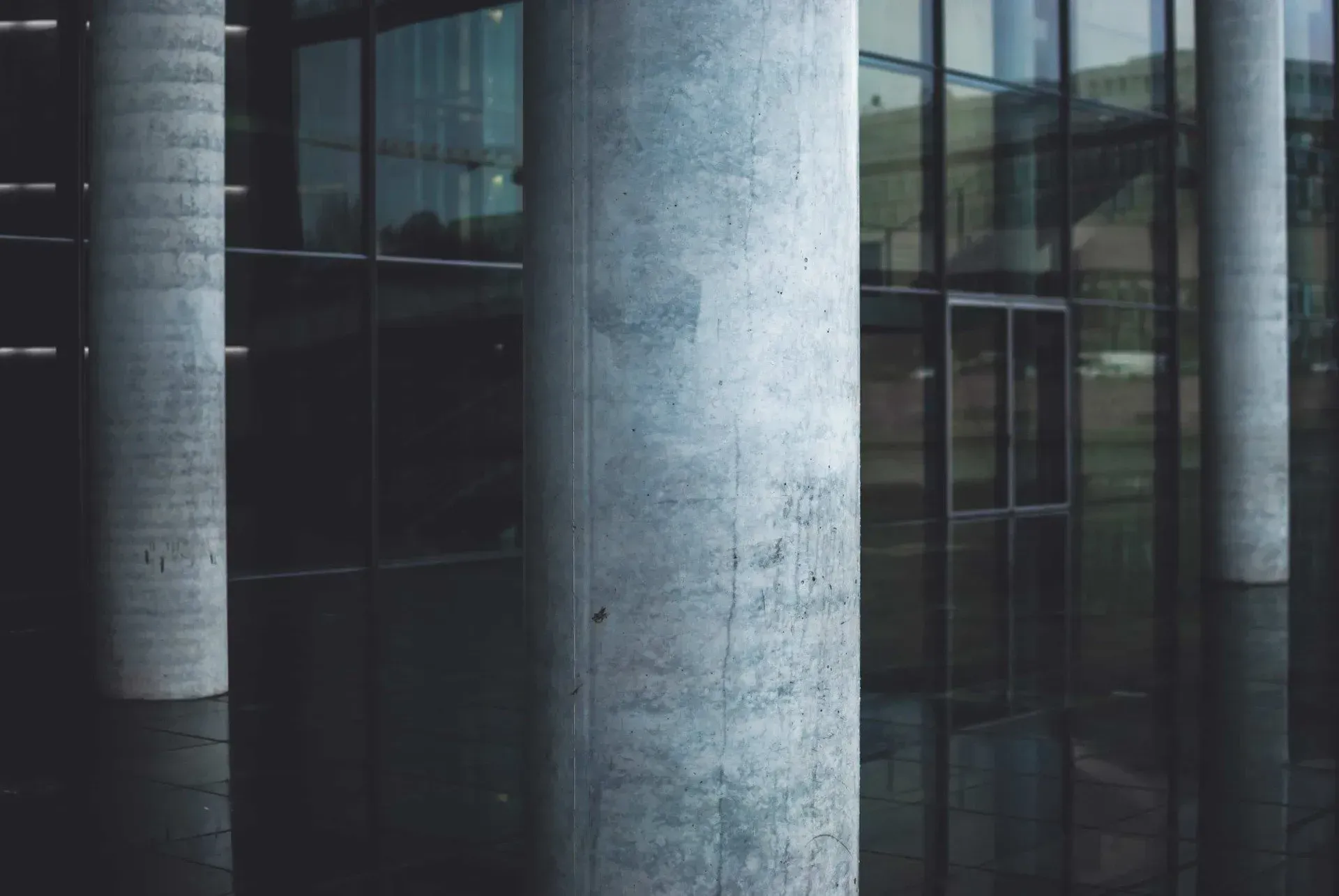 A Building with A Lot of Windows and Columns in Front of It — Concrete Colour Solutions in Morisset, NSW