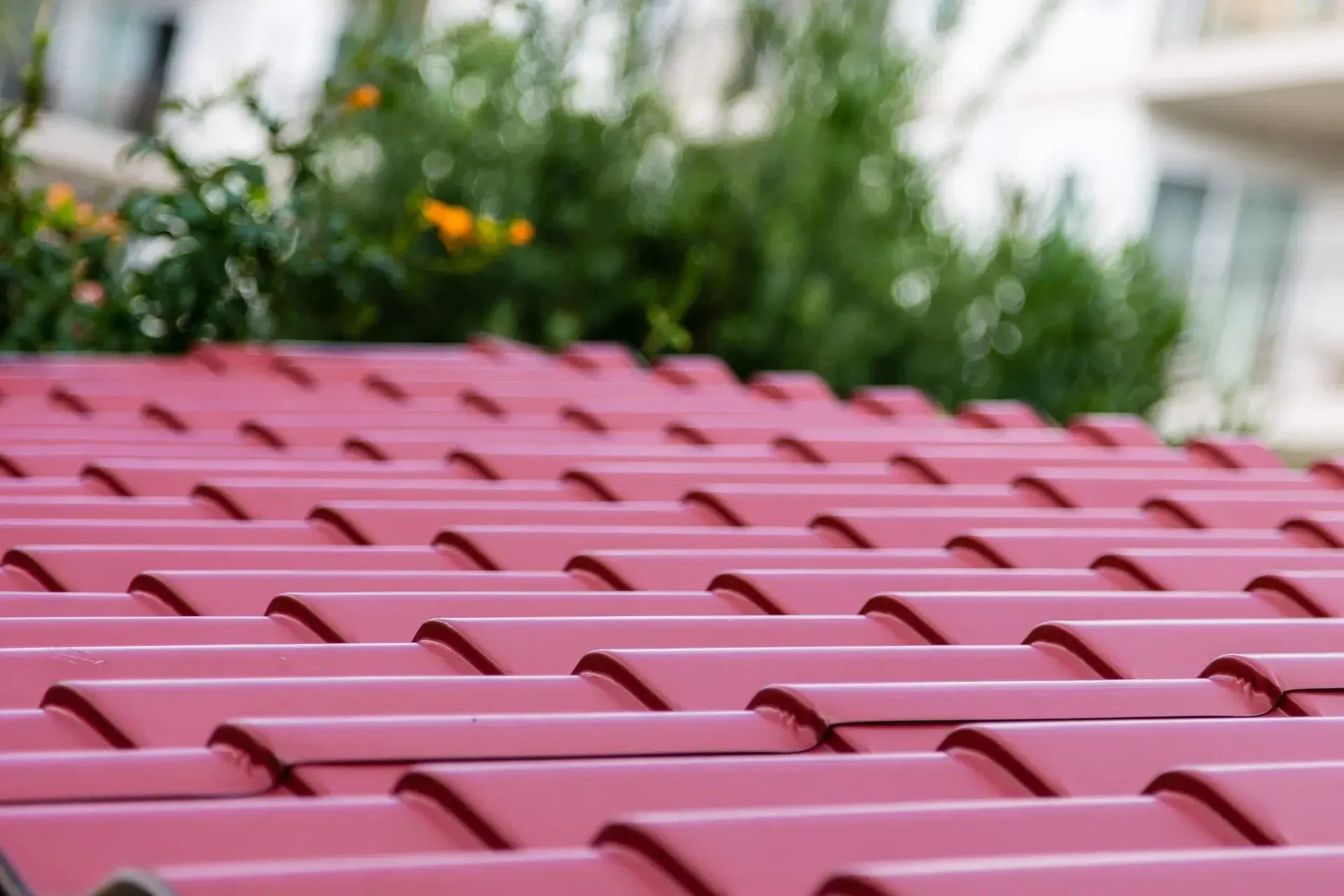 A Close up Of a Red Roof with Flowers in The Background — Concrete Colour Solutions in Morisset, NSW