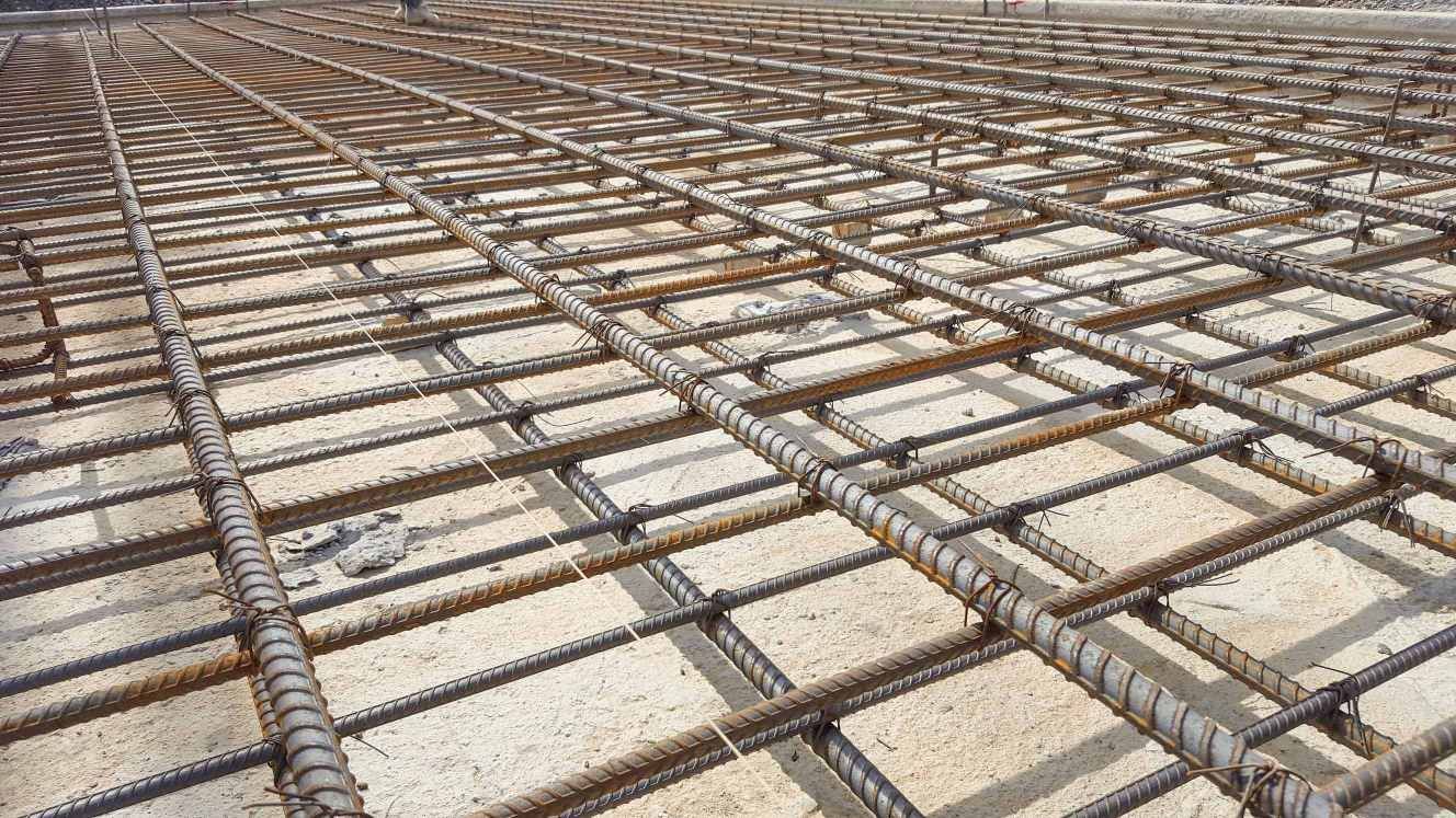 A Close up Of a Concrete Floor with A Grid of Steel Bars — Concrete Colour Solutions in Morisset, NSW