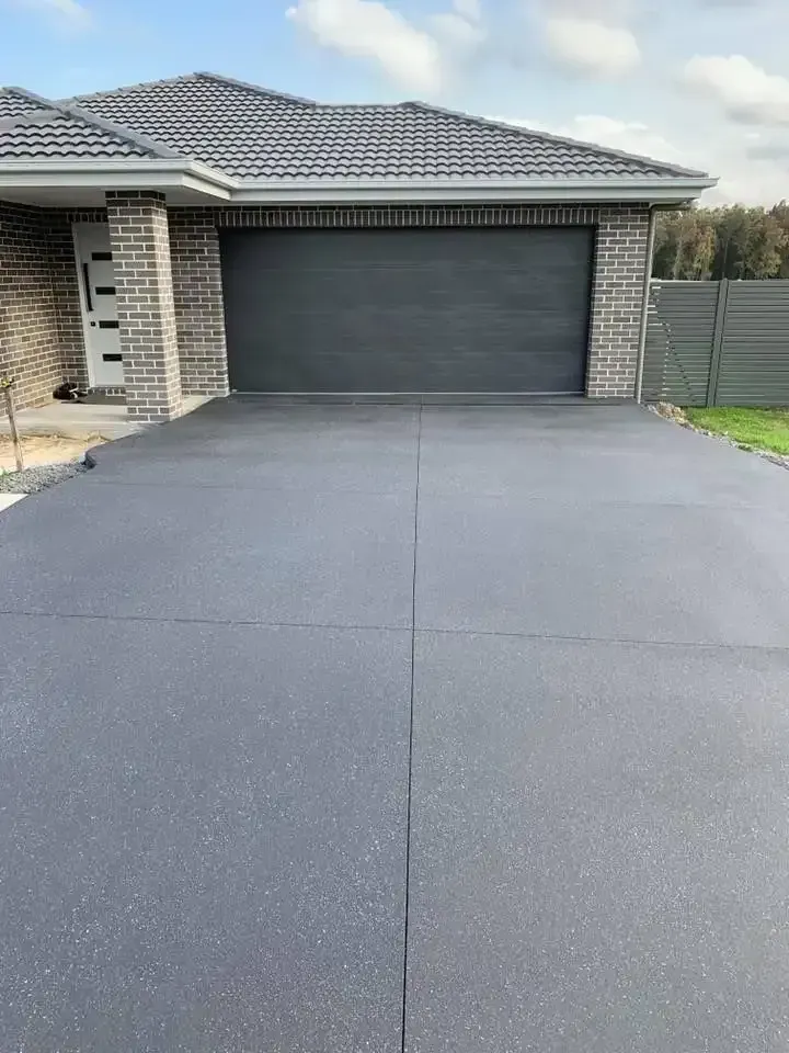 A Driveway Leading to A House with A Garage Door — Concrete Colour Solutions in Maitland, NSW