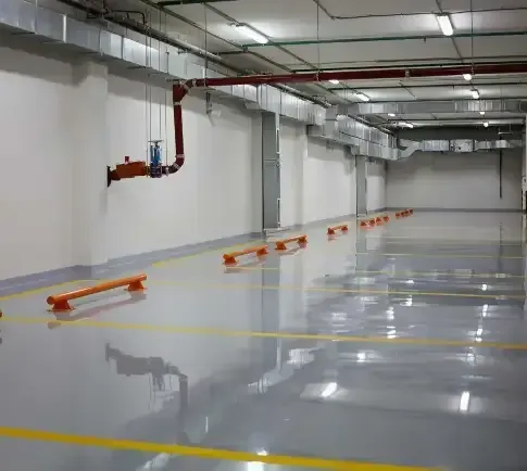 A Large Empty Parking Garage with A Gray Floor and Yellow Lines — Concrete Colour Solutions in Morisset, NSW