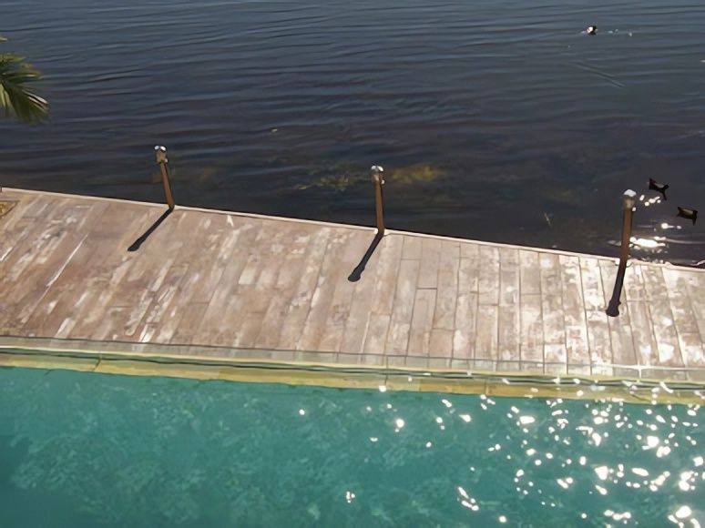 A Wooden Deck Overlooking a Large Body of Water — Concrete Colour Solutions in Morisset, NSW