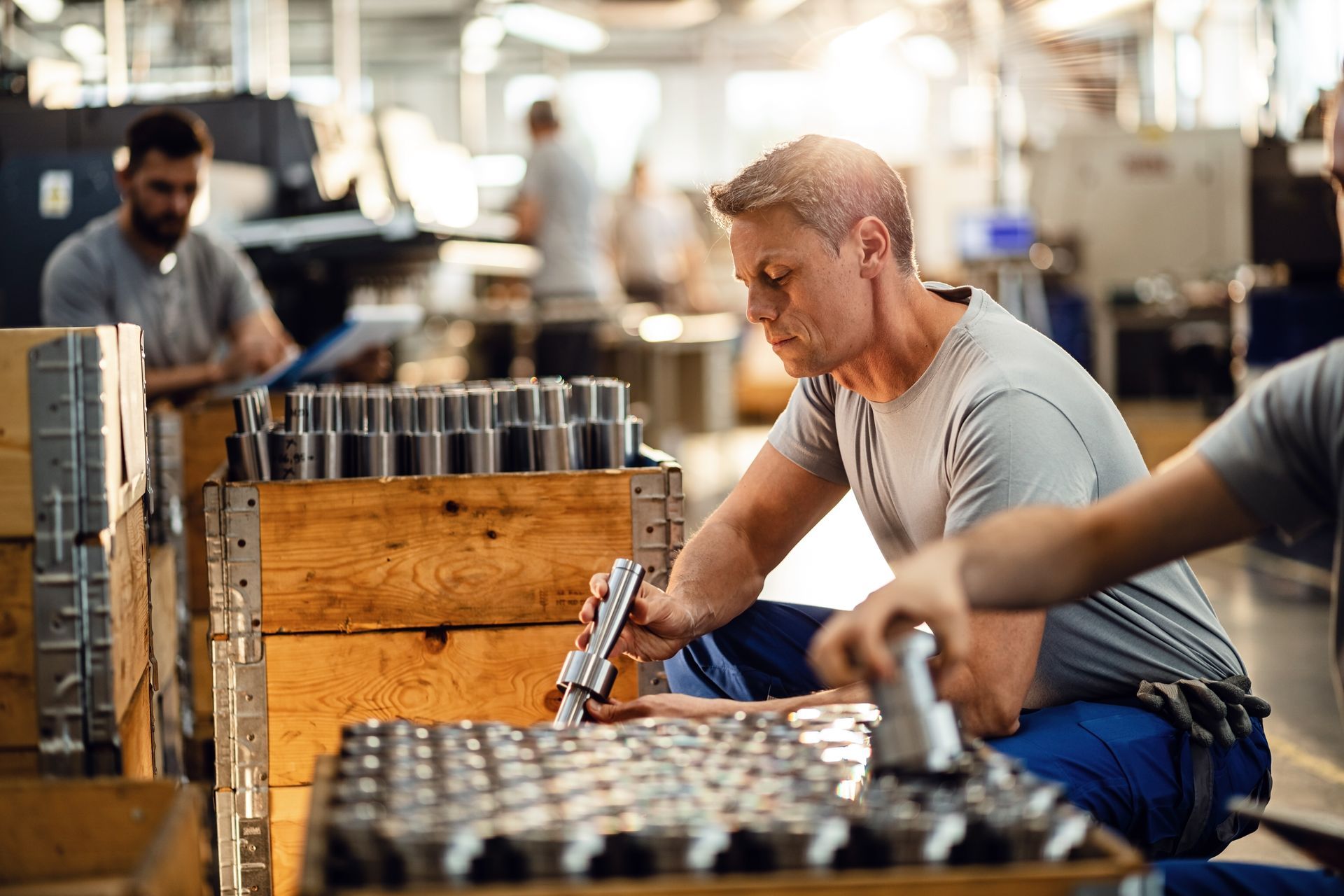 A man is working on a piece of metal in a factory.