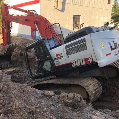 A large excavator is sitting on top of a pile of dirt.