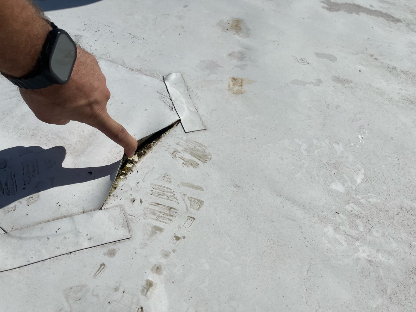 man pointing to hole in roof