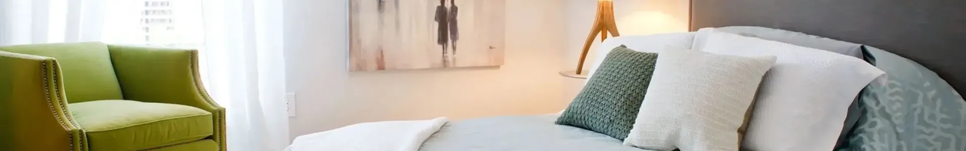 Stylish bedroom with green chair and decorative pillows