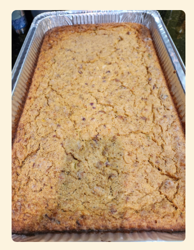 Baked cake or dessert in a foil pan, golden brown with a cracked top