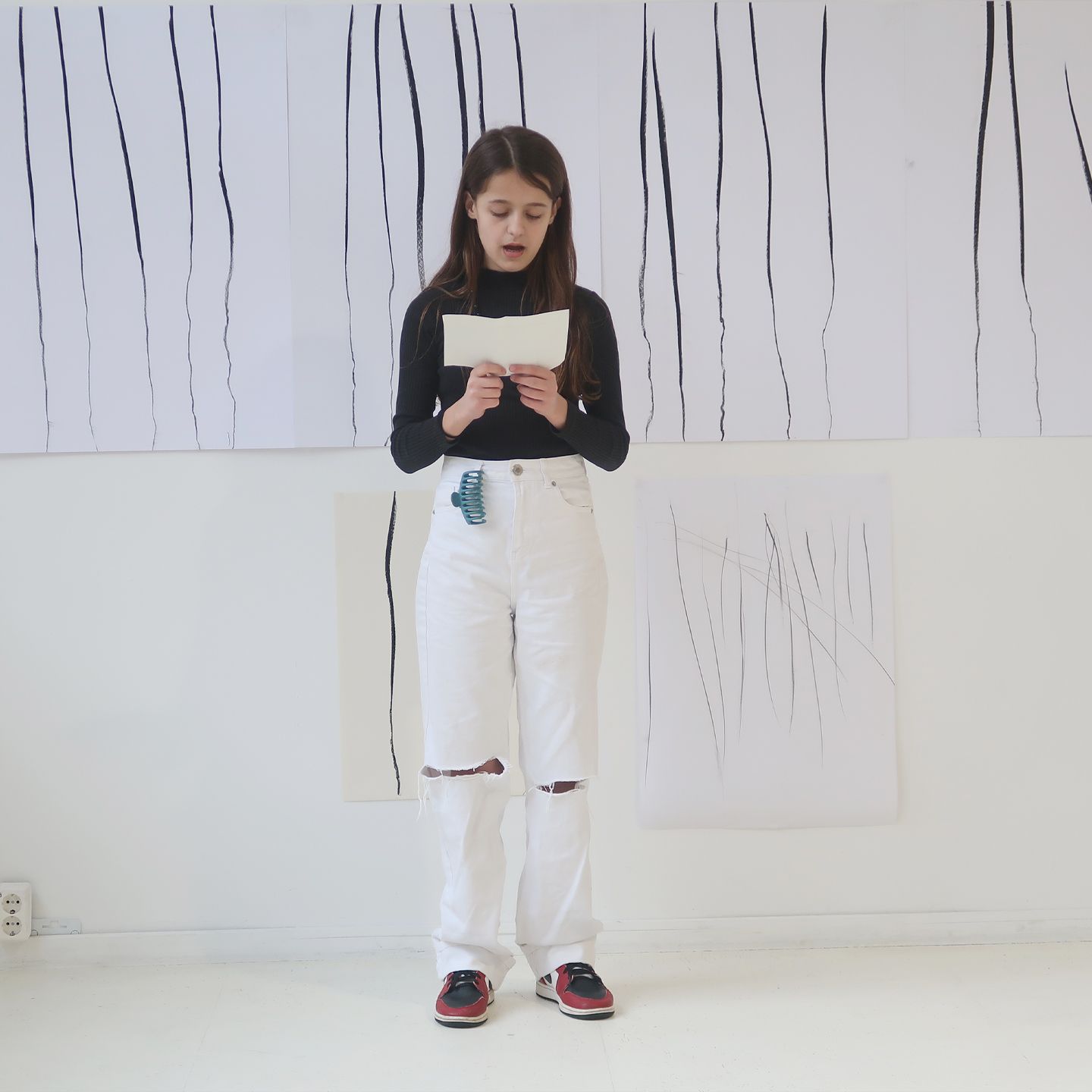 Young girl presenting her artworks during final presentaion.