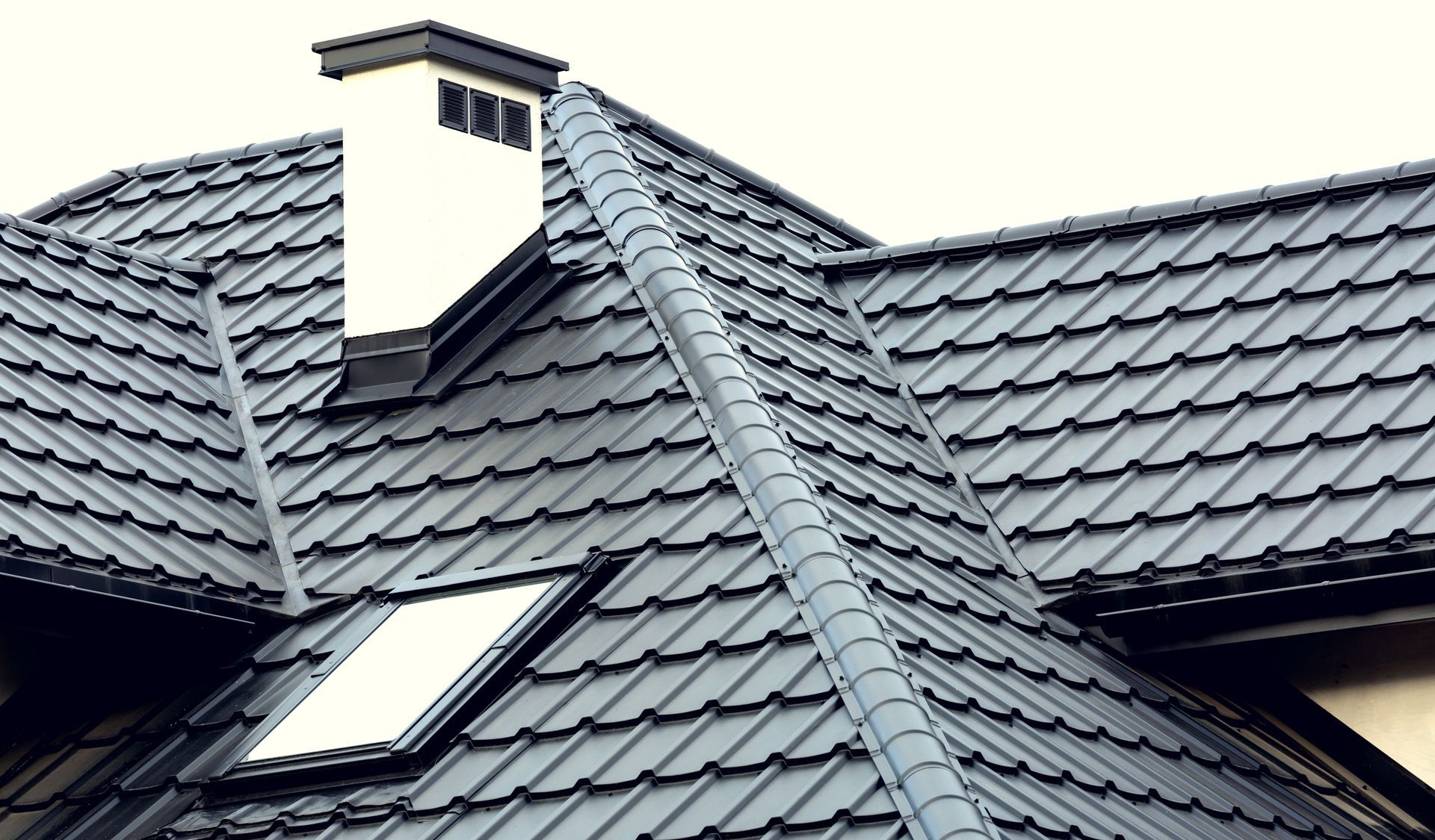 A Roof With Dark Grey Metal Tiles, a White Chimney, and a Skylight Window — The Flue Pro In Huntingfield, TAS