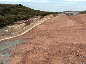 CDTS North & West towed hydroseeder with operator spraying sea defence embankments at Rhyl, North Wales
