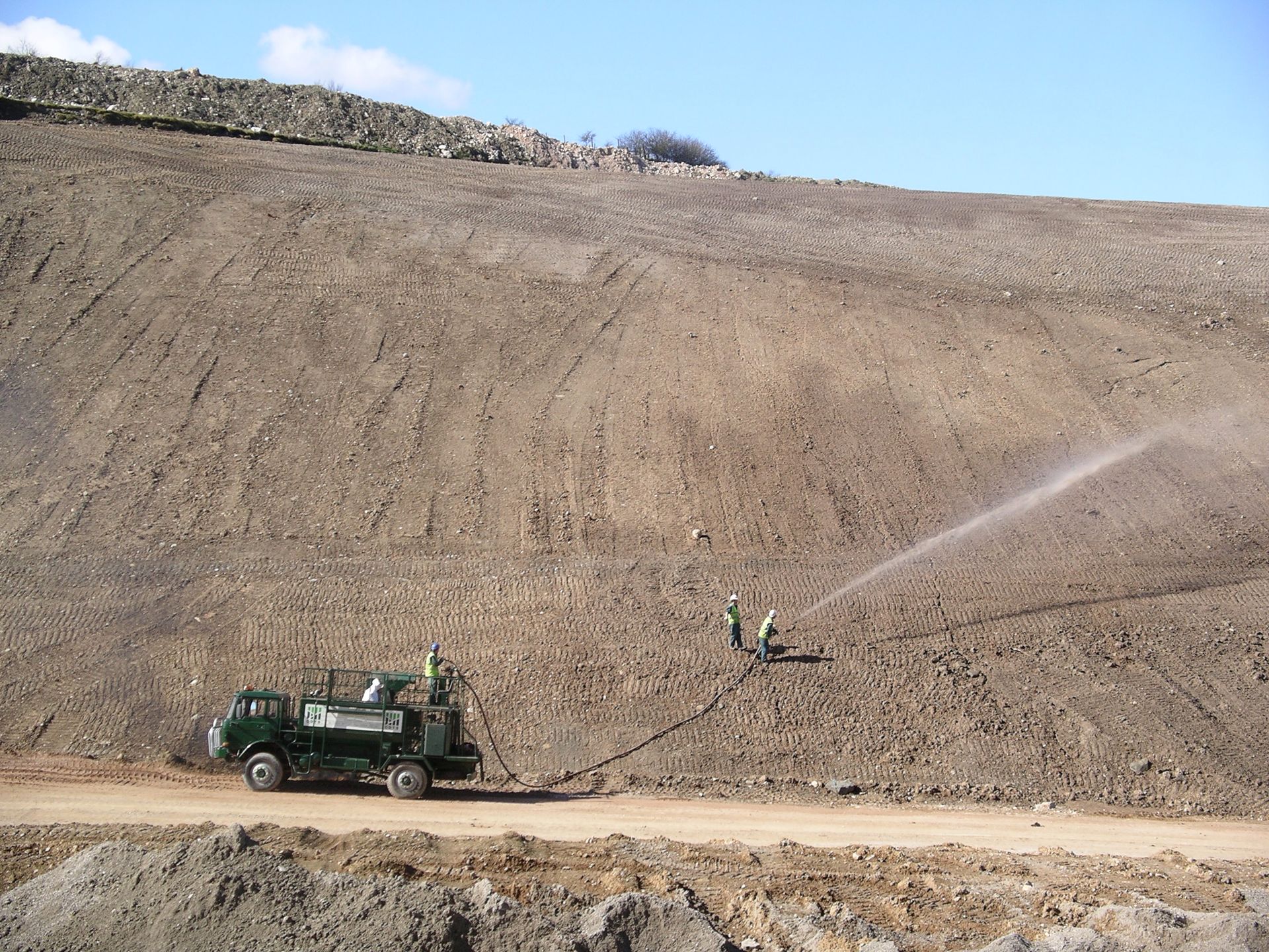 Large, lorry mounted hydroseeder on a steep slope.