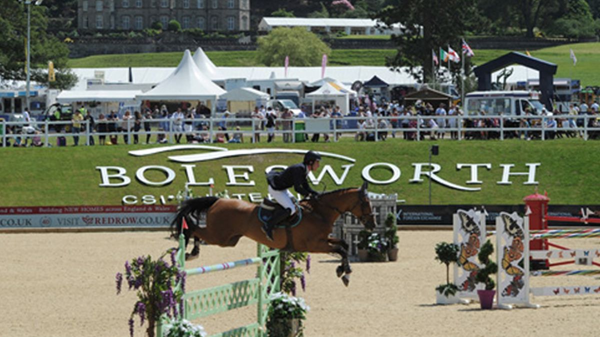 Horse and rider jumping over a decorated fence at the Bolesworth Castle equestrian event.