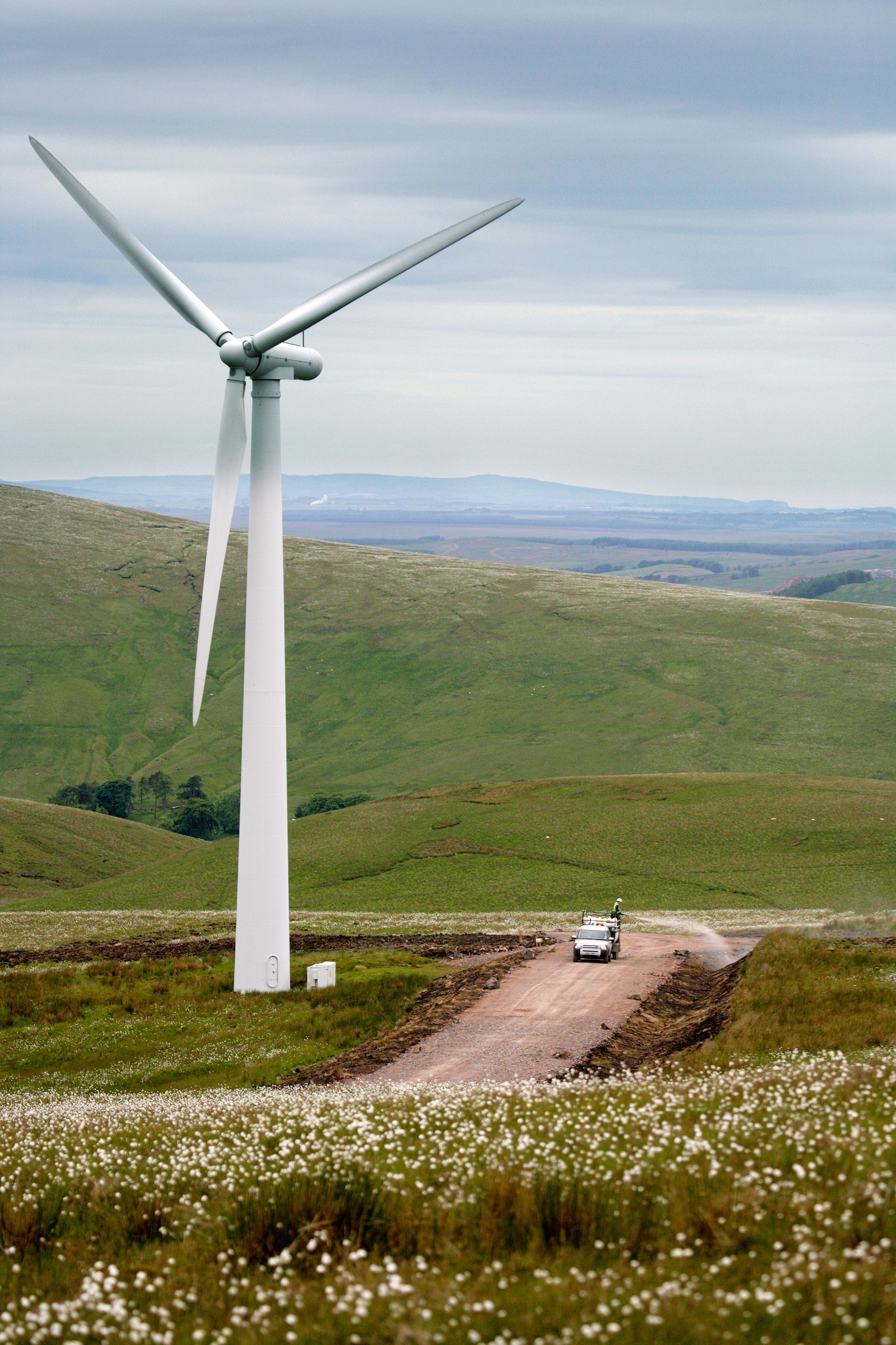 CDTS hydroseeder travelling along access track at Clyde Wind Farm, Scotland, with wind turbines and moorland hills in the background