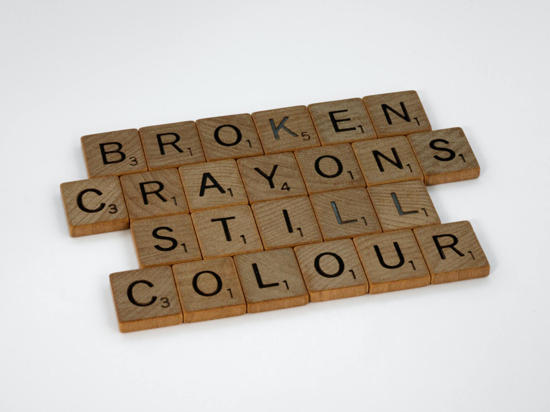 Scrabble letters spelling the phrase 'Broken Crayons Still Colour'