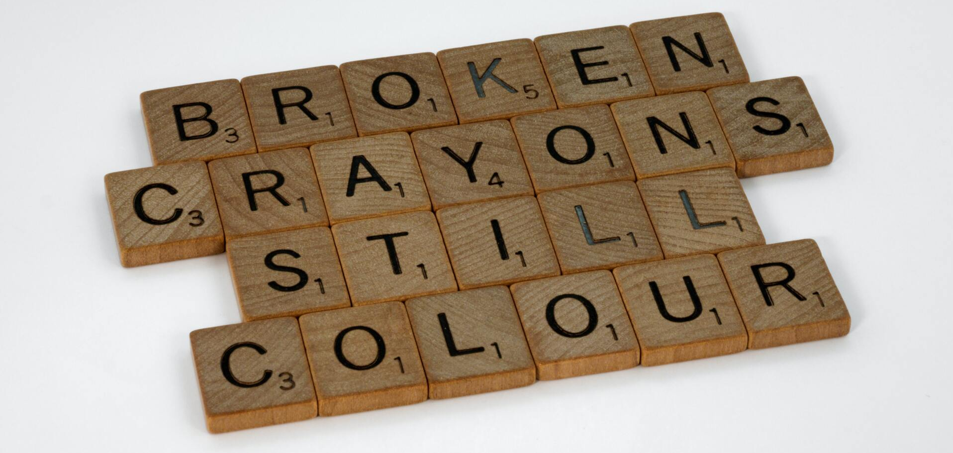 Scrabble letter spelling the phrase 'Broken Crayons Still Colour'