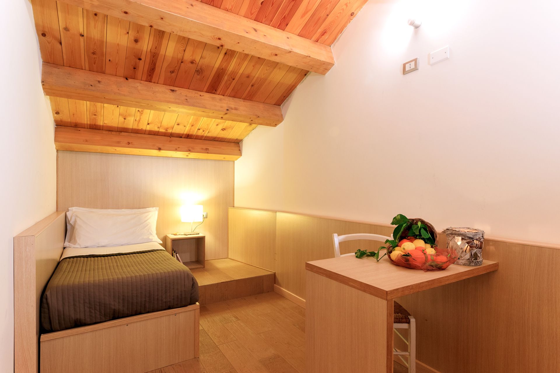 Piccola e accogliente camera da letto con letto singolo, travi in ​​legno.