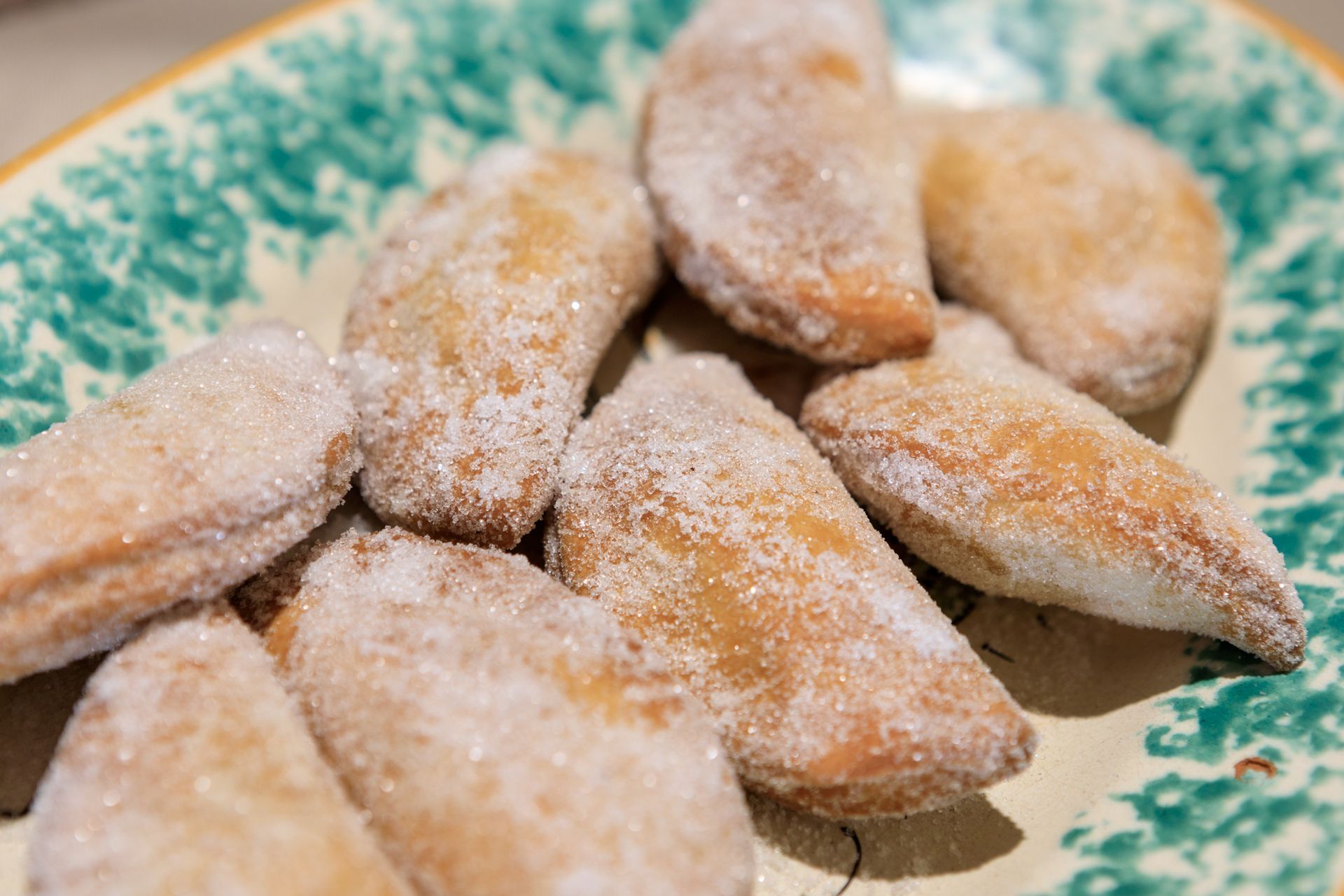 Pasticcini spolverati di zucchero a velo su un piatto decorativo.