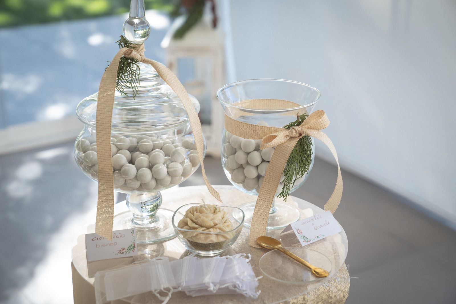 Decorazione rustica bianca per il tavolo del matrimonio con due barattoli di vetro legati in tela di iuta.