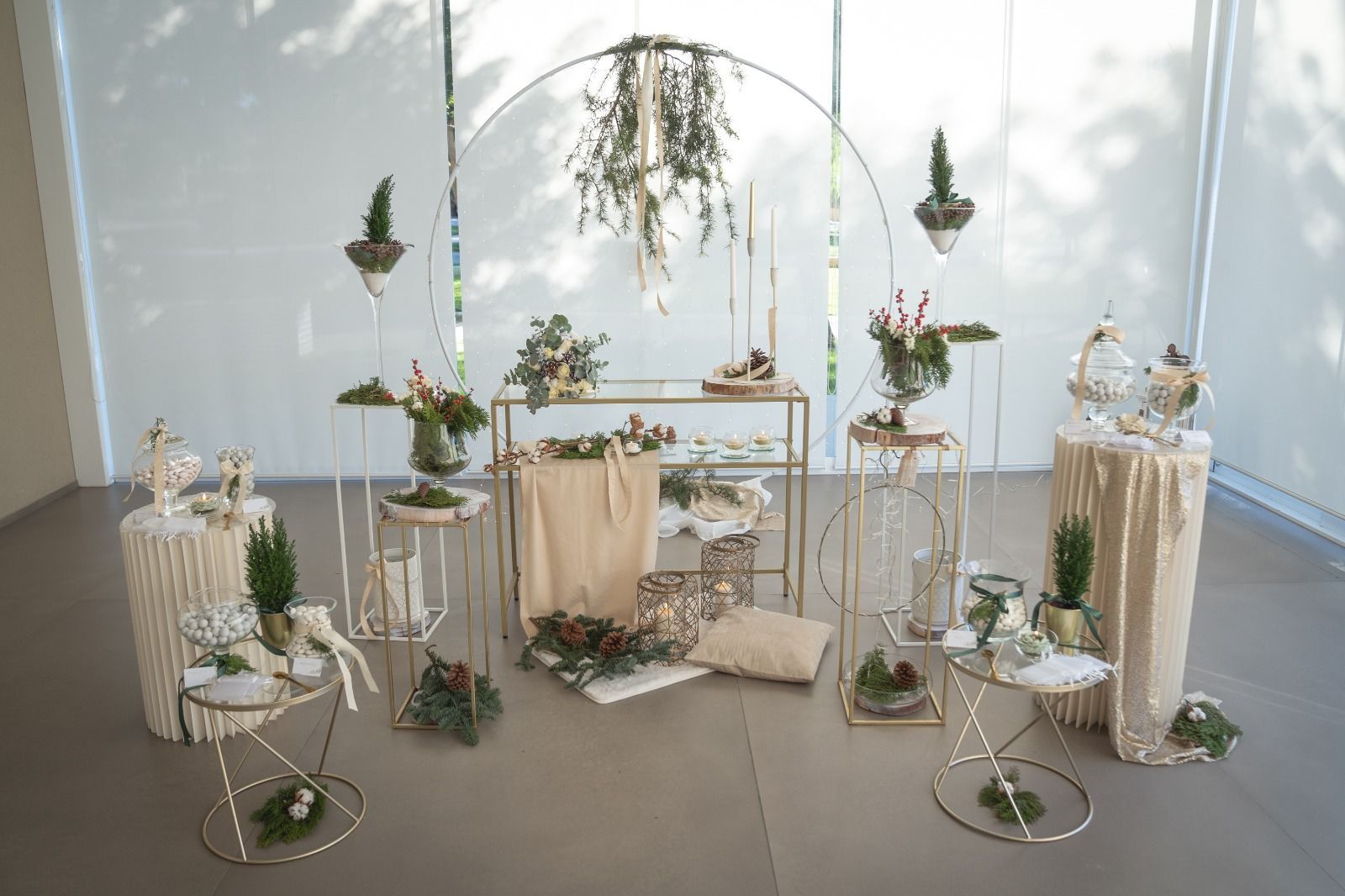 Elegante allestimento nuziale bianco e oro con archi floreali, candele e tavoli drappeggiati, all'interno.