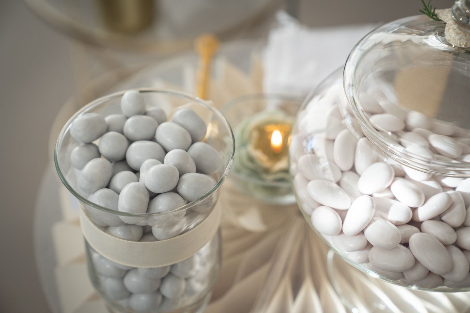Ciotole di vetro contenenti pillole bianche e grigie simili a caramelle.