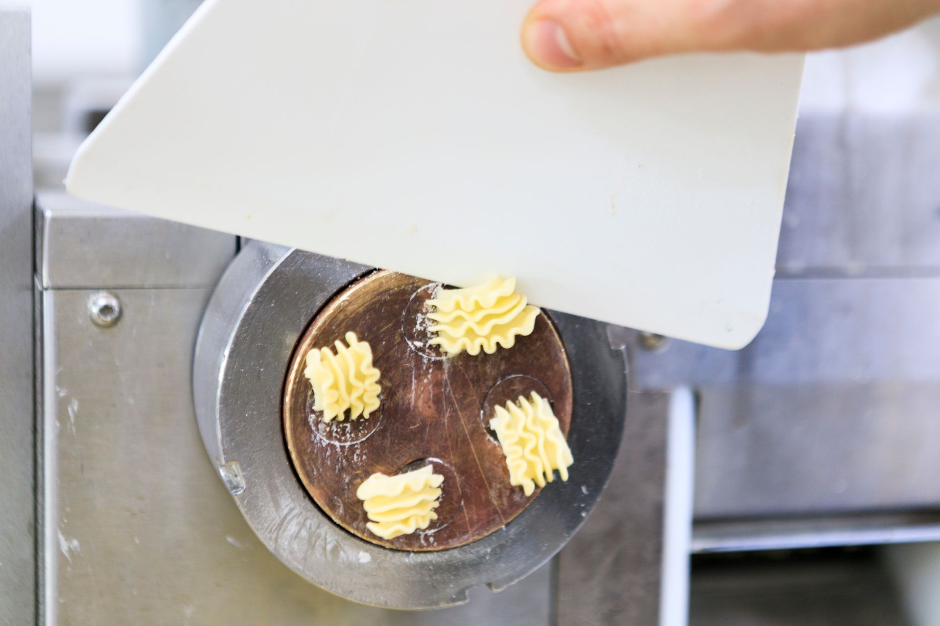Modellare a mano piccole rosette di burro su un dolce rotondo al cioccolato con una sac à poche