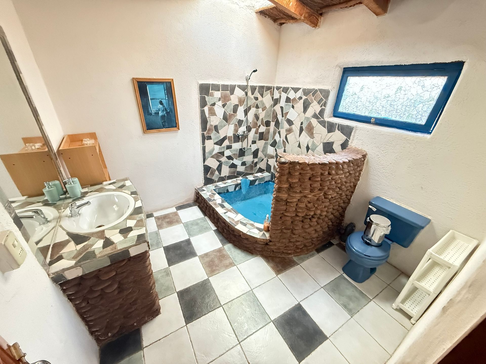 Baño pequeño con suelo de baldosas a cuadros, lavabo, inodoro y ducha con azulejos azules y beige.