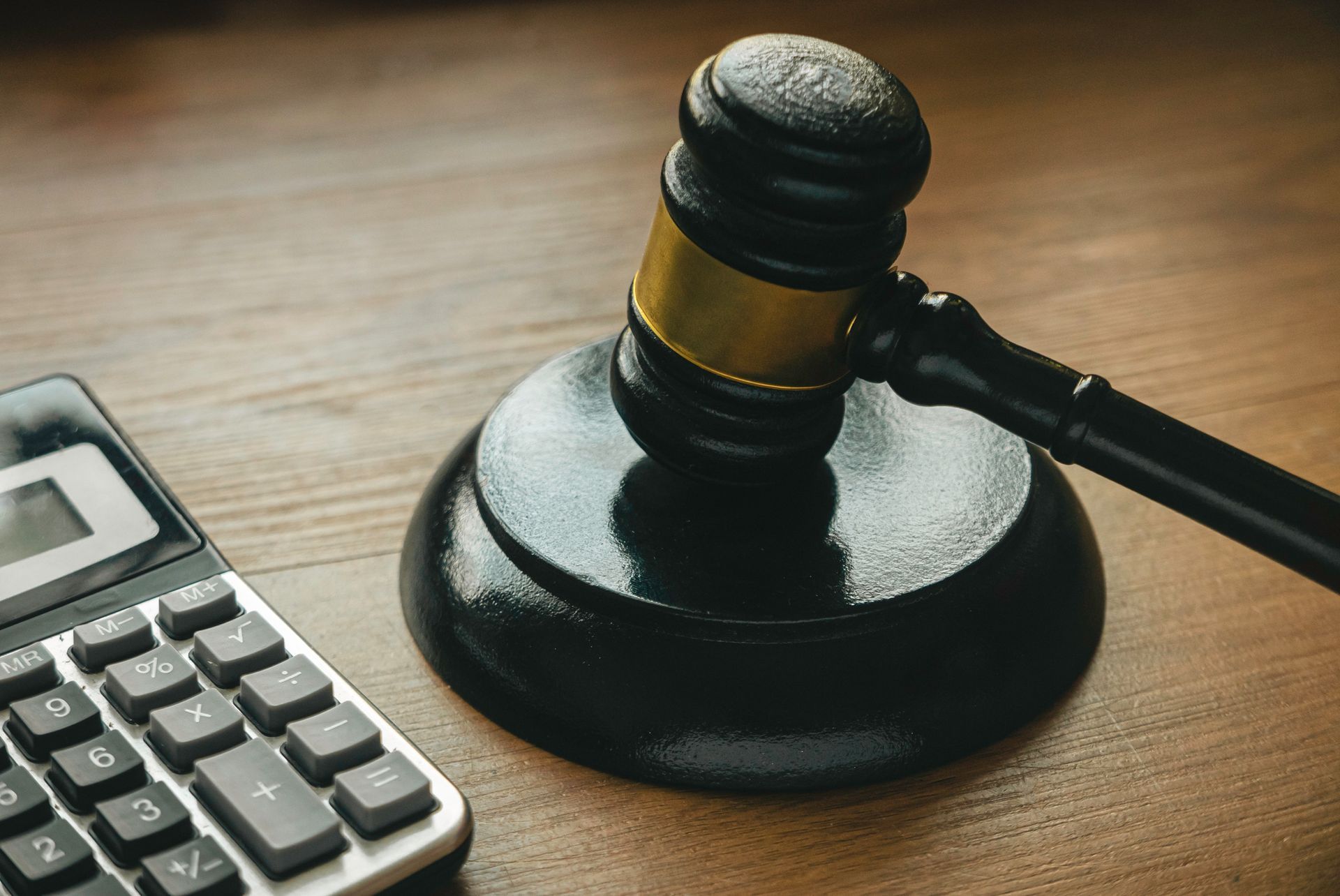 Gavel and calculator on a wooden background.