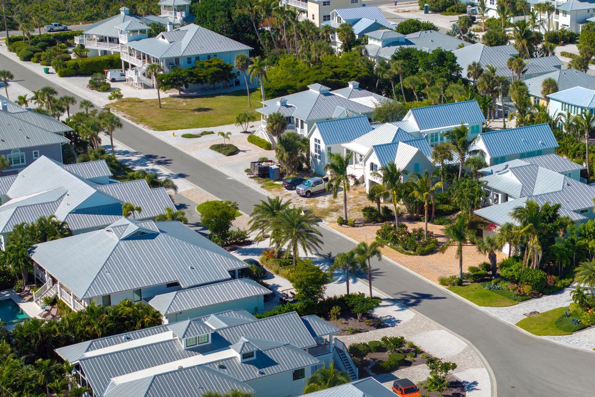 An aerial view of a residential area with lots of houses and palm trees.
