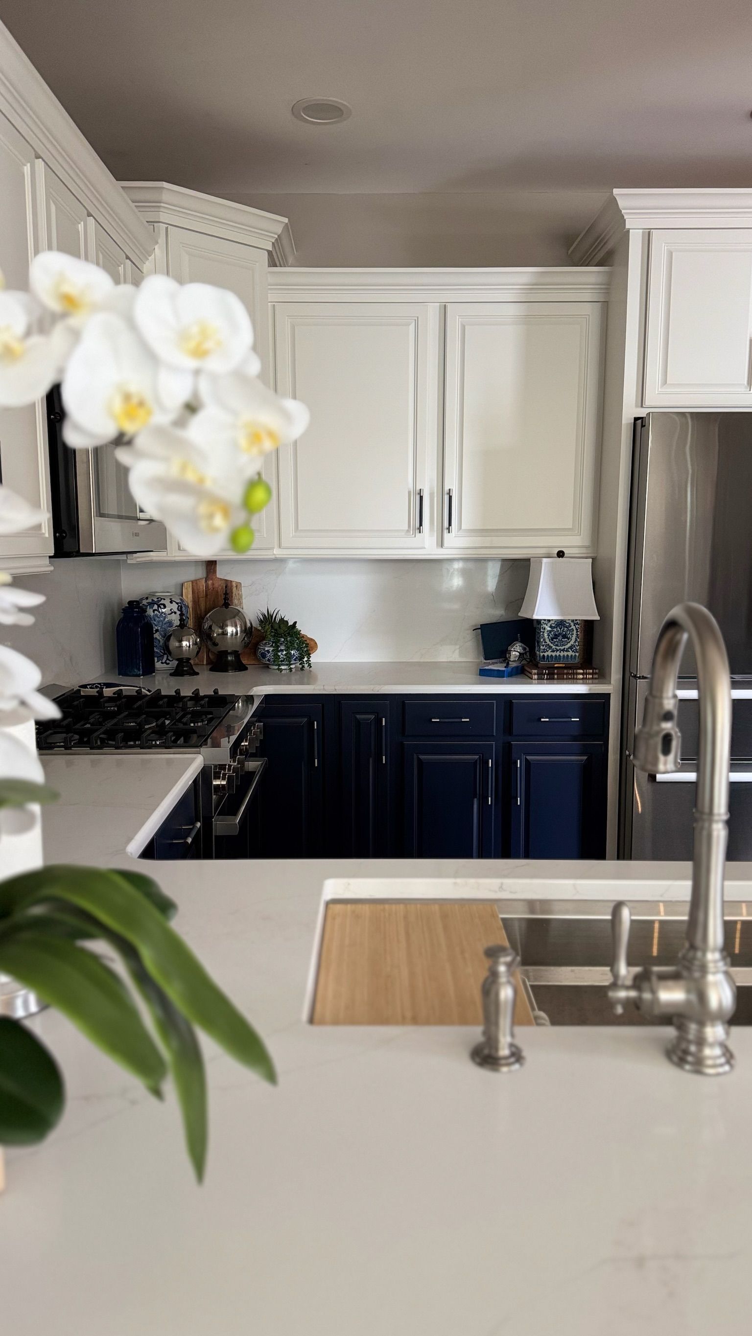 White and navy kitchen with a white orchid.