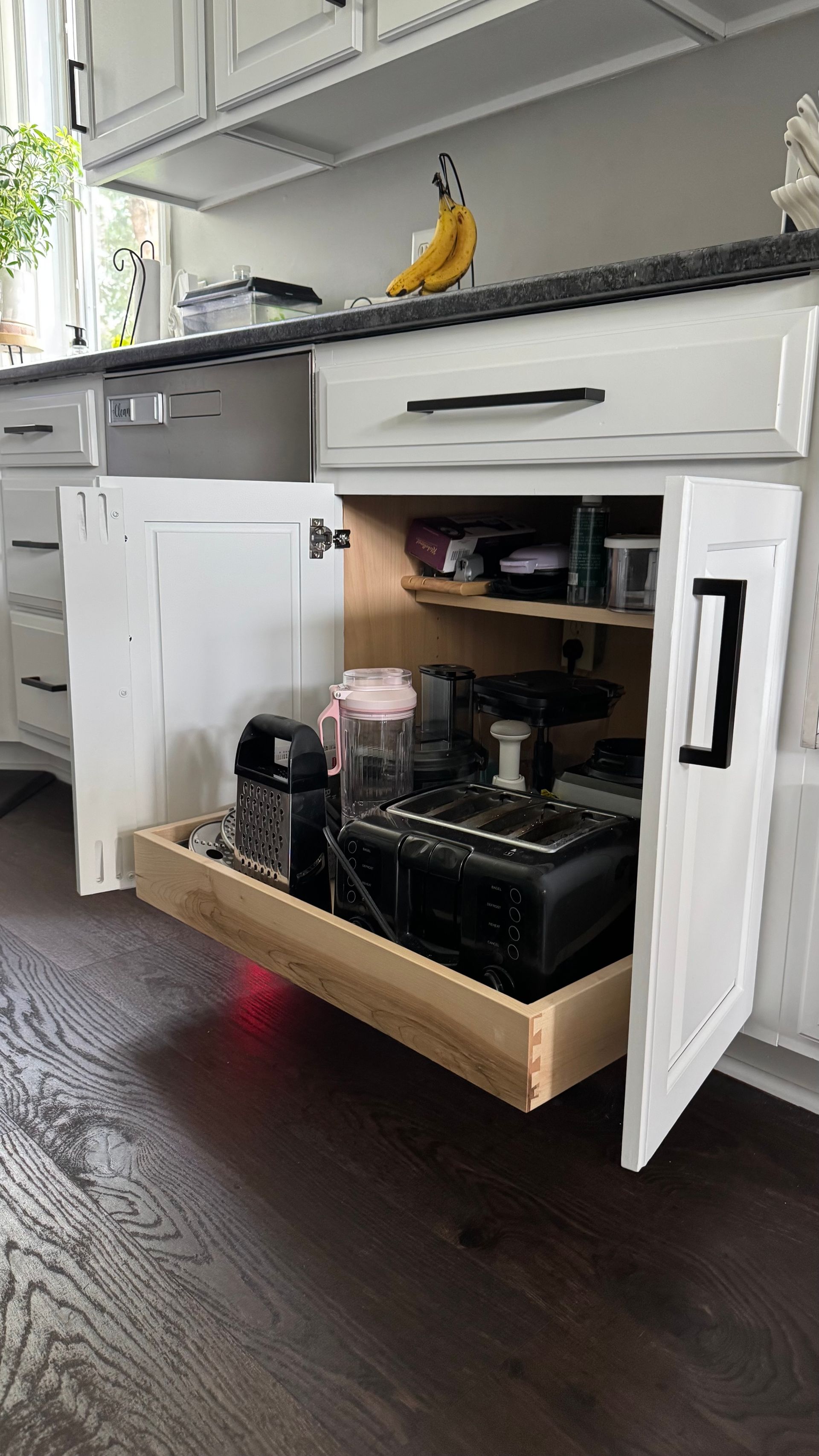 Kitchen cabinet with pull-out drawer holding appliances