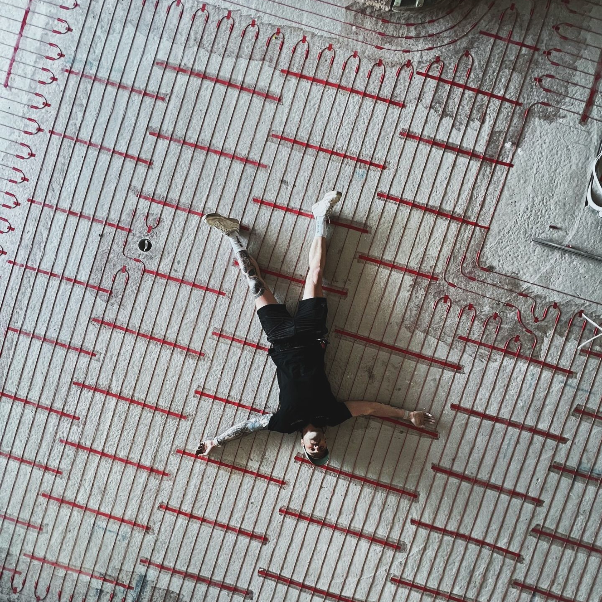 Person lying on patterned floor with arms and legs outstretched.