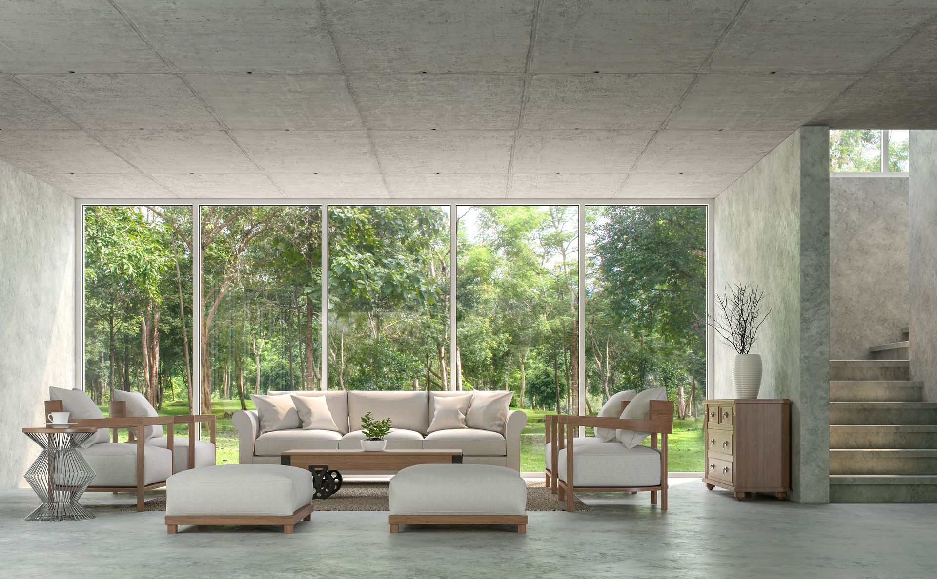 Modern living room with large windows, sofa, armchairs, and lush green trees outside.
