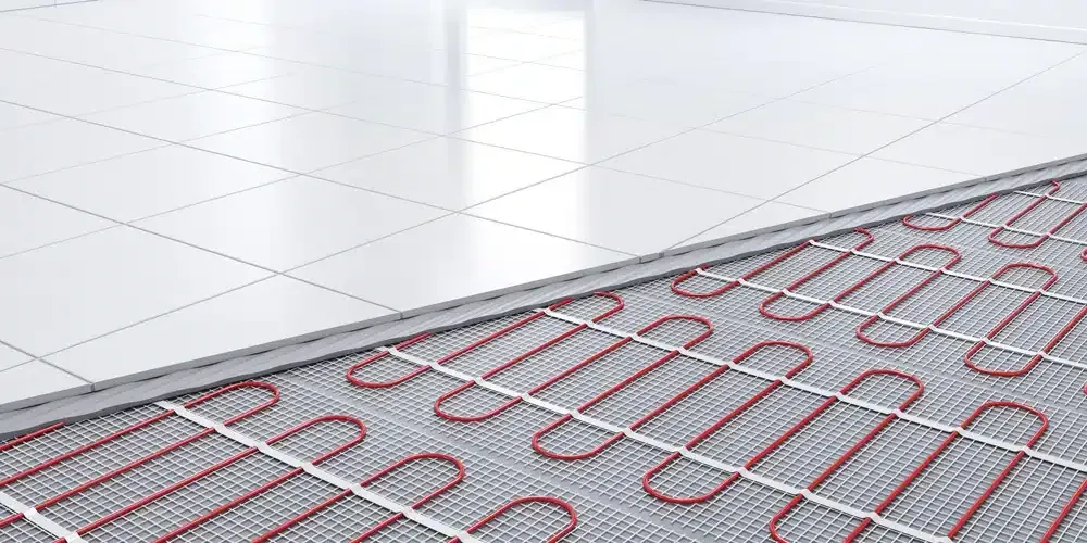 Underfloor heating system with red tubes and white tiled floor.