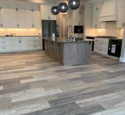 A kitchen with white cabinets and a large island in the middle.