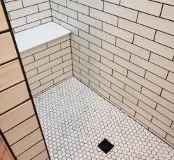 A shower with white brick walls and a white tile floor.