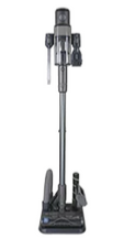 A grey cordless stick vacuum standing upright on its floor attachment, with accessories mounted on the handle and base.