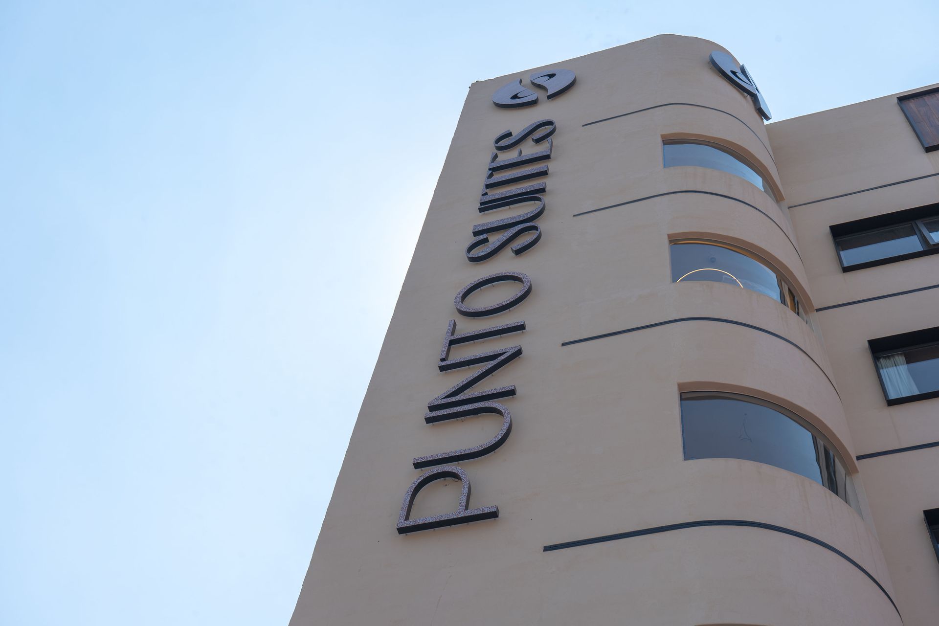 Toma desde un ángulo bajo del exterior de un edificio color canela con las palabras