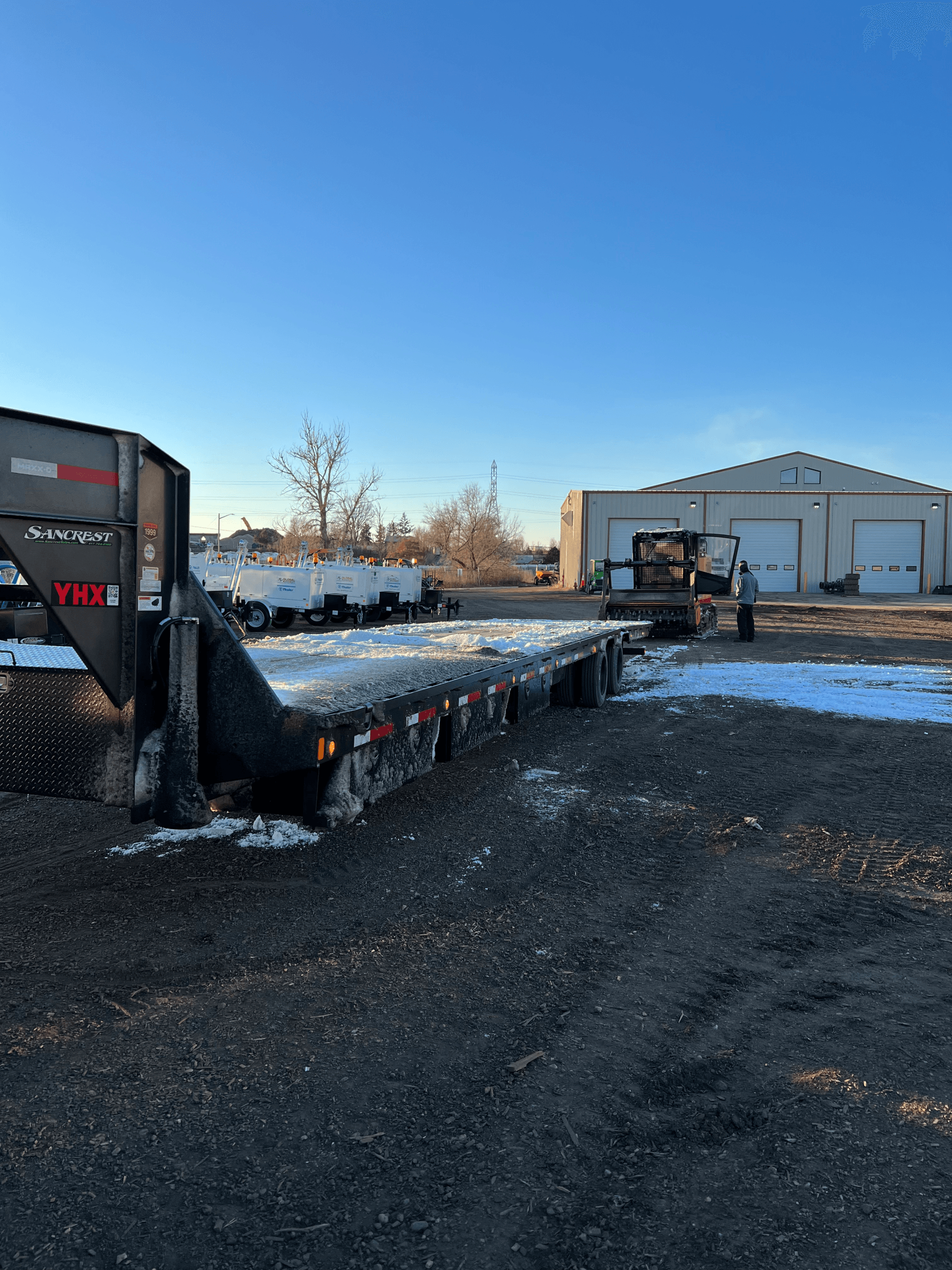 heavy duty construction equipment being loaded on to flatbed trailer