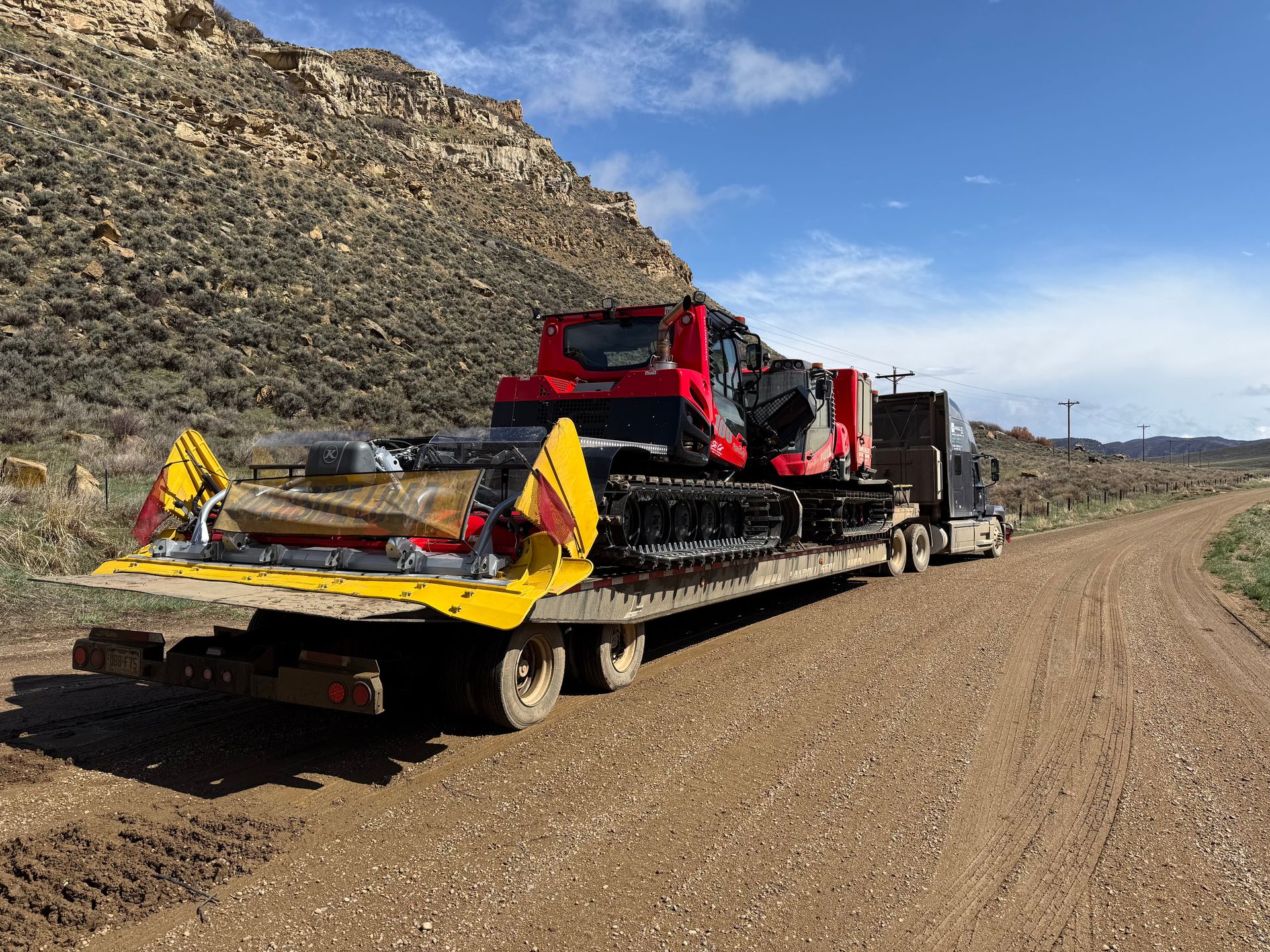 skidster and other equipment transported on flatbed trailer by haul3d