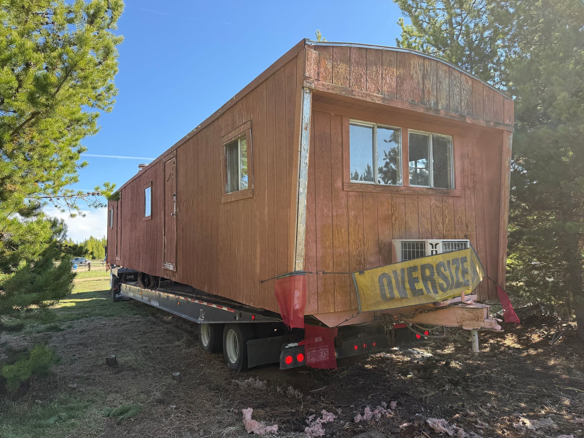 red backhoe on trailer to be transported