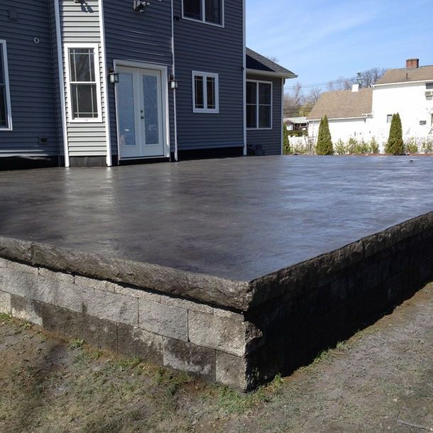 A large concrete deck is in front of a house