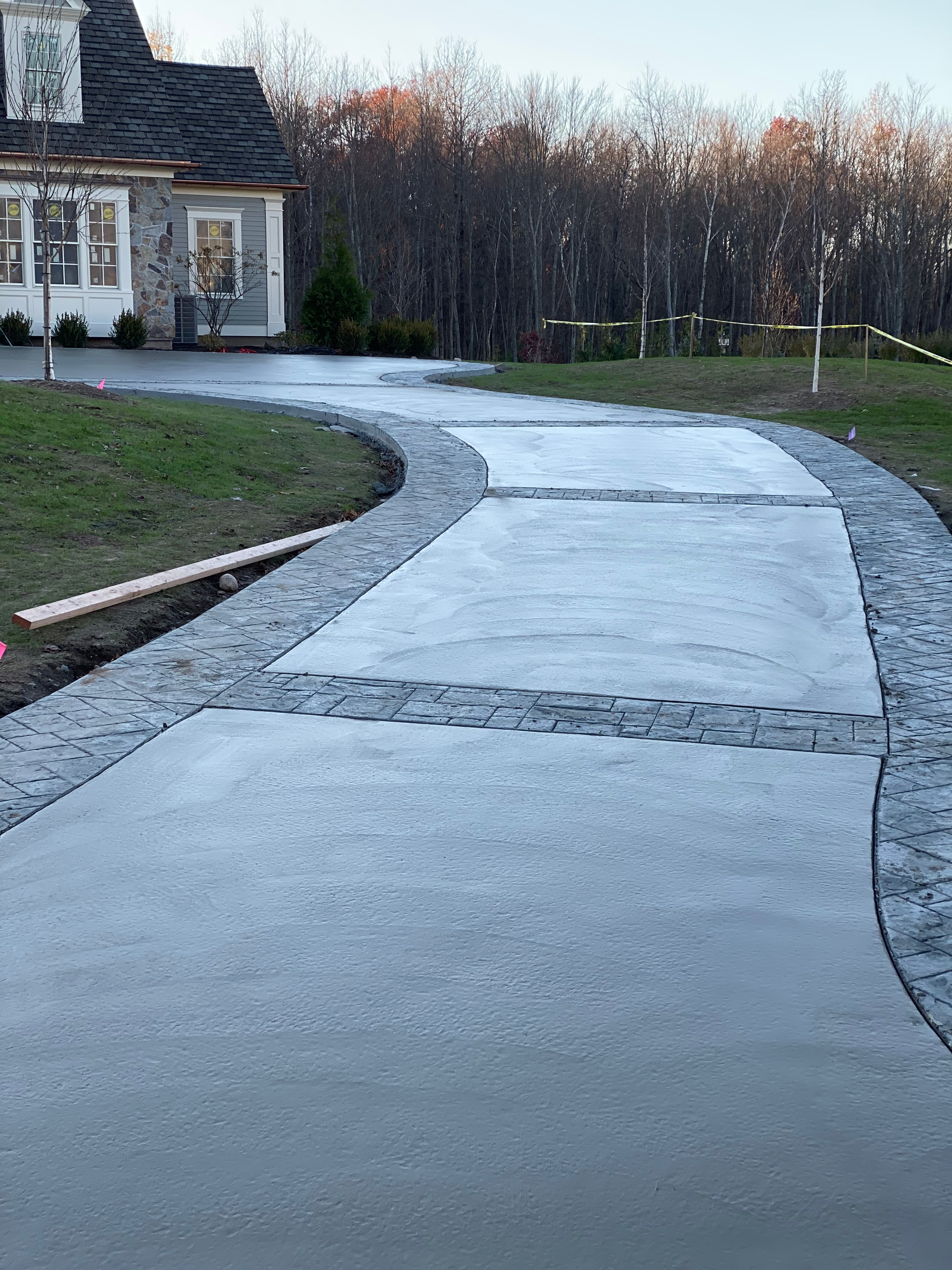 A concrete driveway is being built in front of a house.