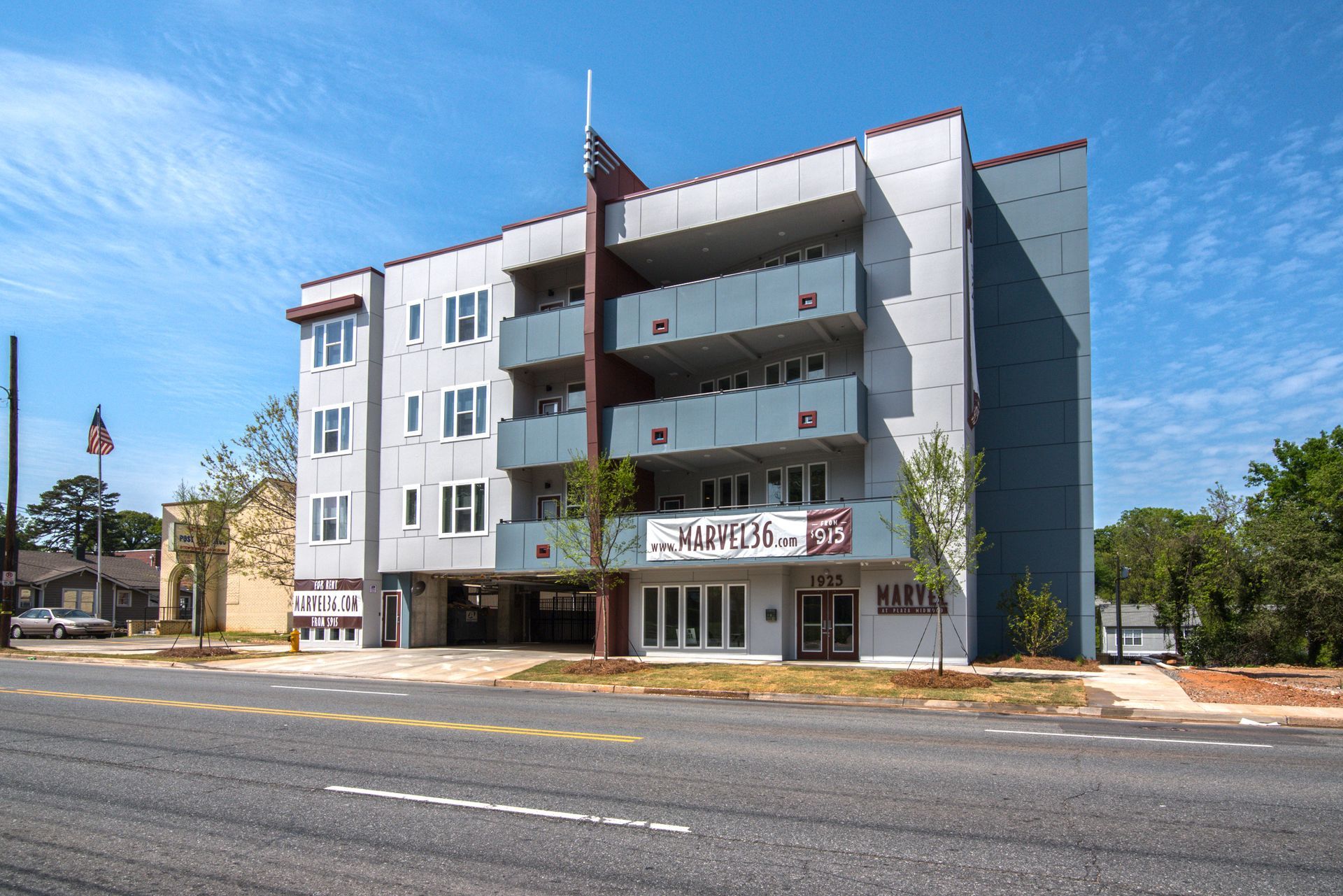 Modern gray apartment building with balconies on a sunny day.